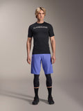 Alpinestars A-Aria Lite Short in Baja Blue, pantaloncini MTB da uomo, indossati con maglia nera a maniche corte e ginocchiere protettive, con perforazioni laser per la ventilazione, abbigliamento tecnico per mountain bike