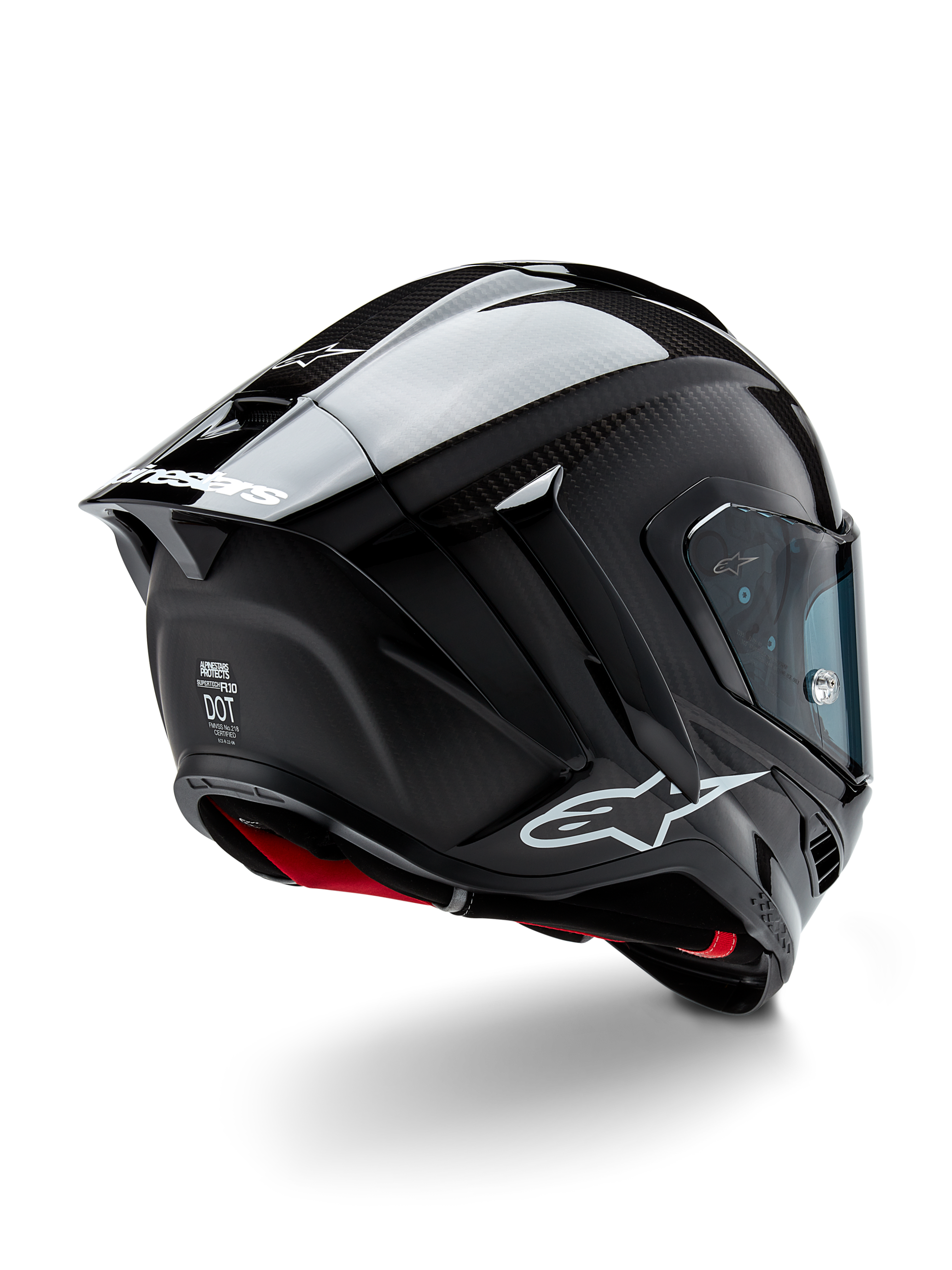 Casco Alpinestars Supertech R10 Solid, casco da racing per moto, finitura in carbonio nero opaco e lucido, vista posteriore a tre quarti che mostra la calotta in fibra di carbonio, lo spoiler aerodinamico e il marchio Alpinestars.