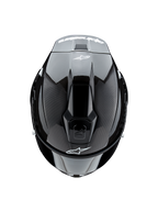 Casco Alpinestars Supertech R10 Solid, vista dall'alto, carbonio nero opaco e lucido, trama in fibra di carbonio sui lati, sezione centrale lucida, prese d'aria aerodinamiche, logo Alpinestars bianco anteriore e posteriore