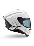 Casco Alpinestars Supertech R10 Solid, casco da moto racing bianco lucido e nero opaco, vista laterale di profilo, design aerodinamico con alette posteriori e prese d'aria laterali, visiera con tinta blu, caratterizzato dal logo a stella Alpinestars nero sul lato