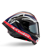 Casco Alpinestars Supertech R10 Team, casco da moto racing, carbonio nero con accenti rosso fluo e blu opaco, grande logo Alpinestars bianco, design aerodinamico con spoiler integrati, visiera trasparente, trama in fibra di carbonio a vista, profilo racing elegante