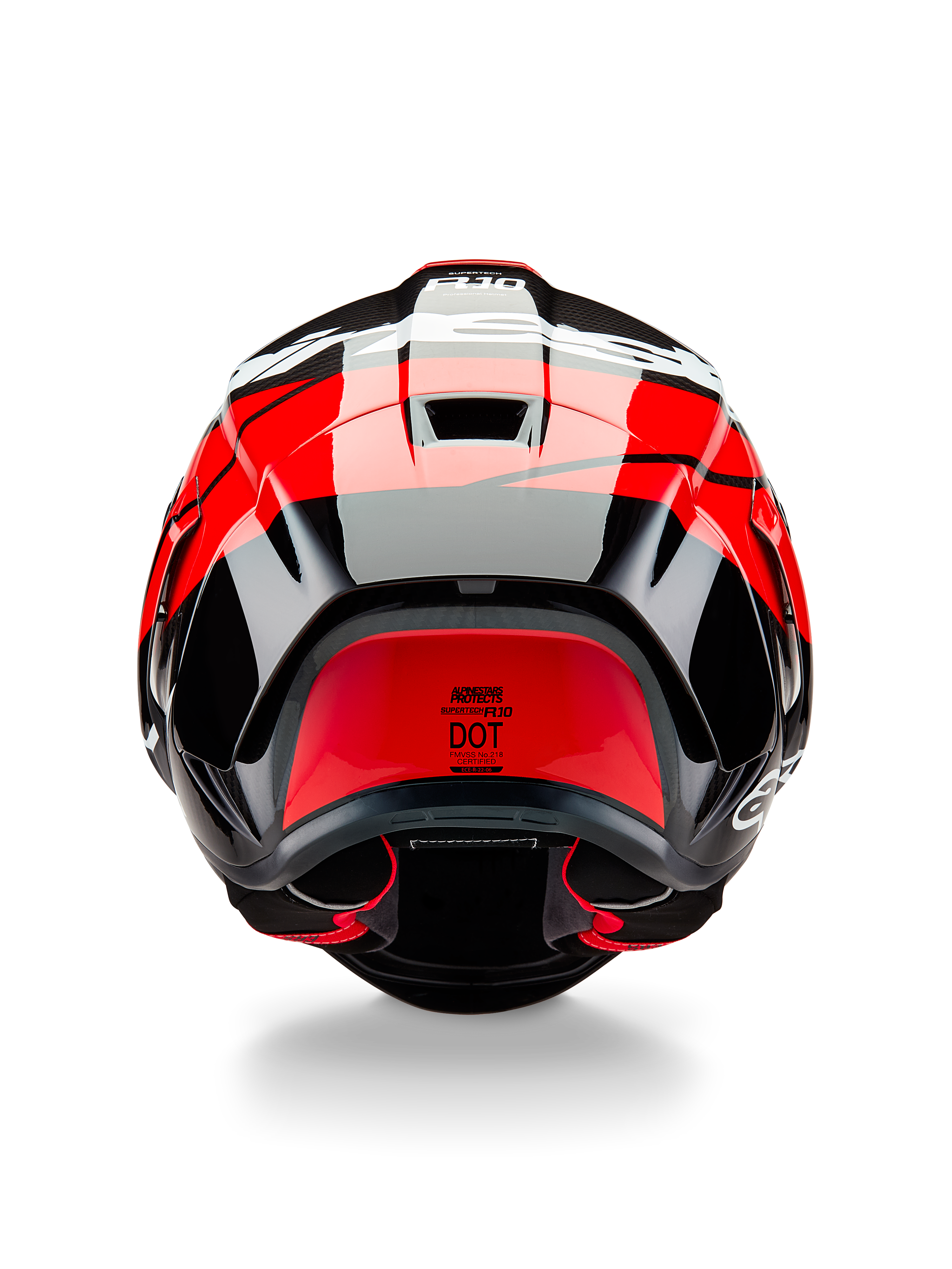 Casco Alpinestars Supertech R10 Element, vista posteriore, nero carbonio con accenti rosso brillante e bianco lucido, con spoiler posteriore aerodinamico, prese d'aria di scarico ed etichetta di certificazione DOT, design elegante di ispirazione racing con dettagli in fibra di carbonio