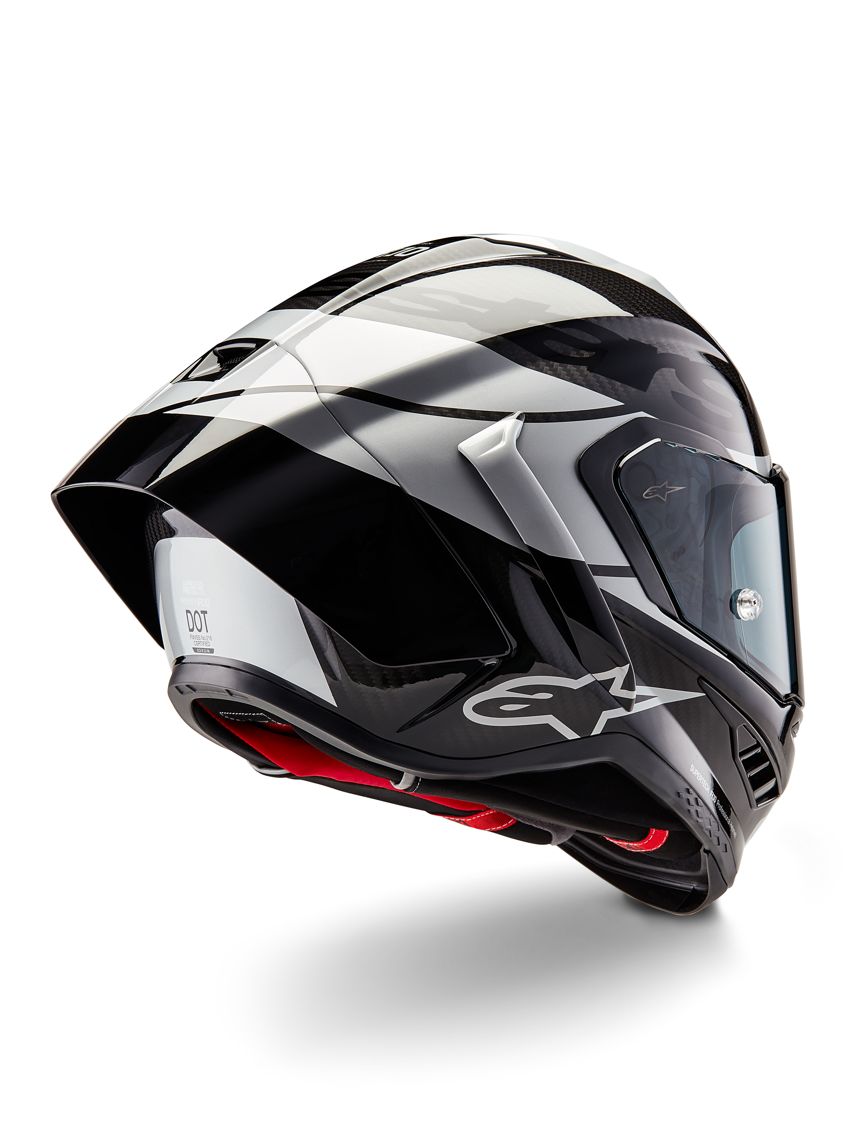 Casco Alpinestars Supertech R10 Element, Nero Carbonio Argento Nero Lucido, vista posteriore a tre quarti che mostra il profilo aerodinamico da corsa, calotta in fibra di carbonio lucida con grafiche geometriche grigie e nere, logo Alpinestars e imbottitura interna rossa