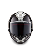 Casco Alpinestars Supertech R10 Element, casco integrale da corsa, nero carbonio e argento lucido, vista frontale con visiera fumé scura, trama in fibra di carbonio lucida, grafiche aerodinamiche argento e loghi Alpinestars