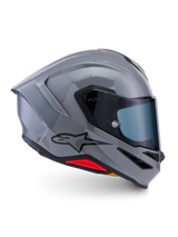Casco Alpinestars S-R7 Solid, casco moto integrale, grigio lucido, vista laterale di profilo, calotta aerodinamica grigio lucido con logo nero e accenti rossi alla base, equipaggiamento per guida sportiva e corse ad alte prestazioni