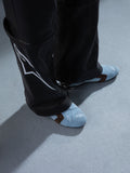 Alpinestars RSRV Starline Shoes, scarpe casual lifestyle azzurre con dettagli marroni, design perforato, logo bianco, indossate con pantaloni in pelle nera con design bianco