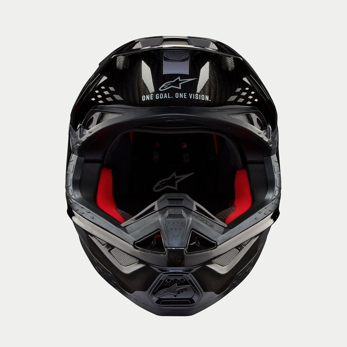 Casco Alpinestars Supertech M10 Solid, casco da motocross, carbonio nero lucido, vista frontale con imbottitura interna rossa, calotta in fibra di carbonio e slogan "ONE GOAL. ONE VISION." sulla zona della visiera