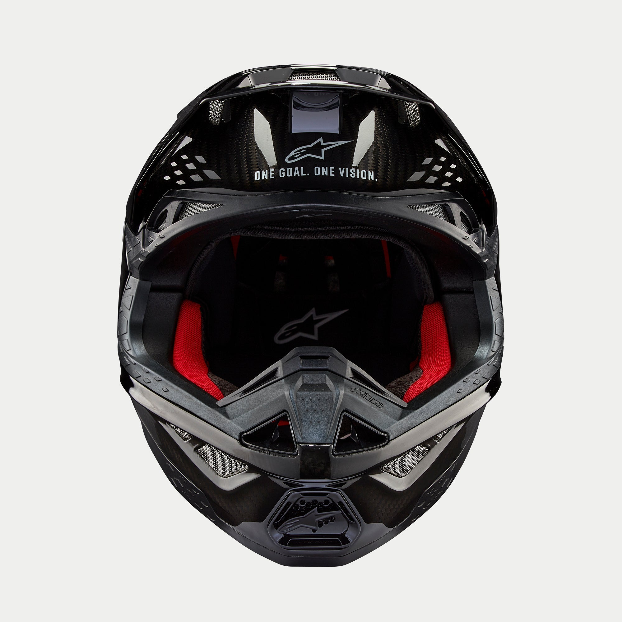 Casco Alpinestars Supertech M10 Solid, casco da motocross, carbonio nero lucido, vista frontale con imbottitura interna rossa, calotta in fibra di carbonio e slogan "ONE GOAL. ONE VISION." sulla zona della visiera