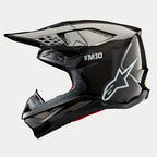 Casco Alpinestars Supertech M10 Solid, casco da motocross, carbonio nero lucido, profilo laterale con trama in fibra di carbonio a vista, marchio SM10 e logo Alpinestars bianchi, design aerodinamico con prese d'aria coperte da rete