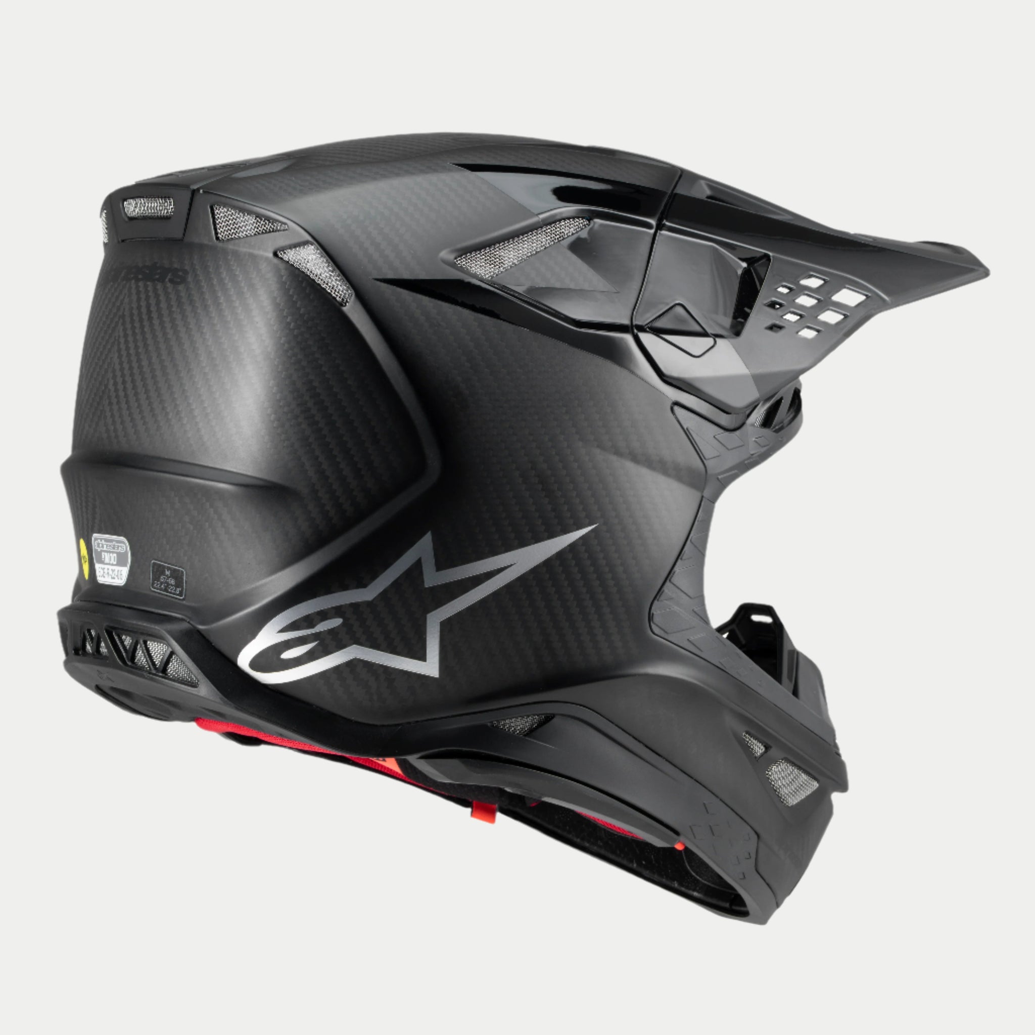 Alpinestars Supertech M10 Fame Helmet, casco da motocross, carbonio nero opaco e lucido, vista posteriore di tre quarti con trama in fibra di carbonio a vista, logo argento e molteplici prese d'aria integrate, protezione avanzata per la testa fuoristrada