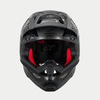 Casco Alpinestars Supertech M10 Fame ECE 22.06, casco da motocross, carbonio nero opaco e lucido, vista frontale con imbottitura interna rossa visibile, calotta aerodinamica in fibra di carbonio, design ventilato per gare fuoristrada