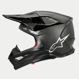 Casco Alpinestars Supertech M10 Fame ECE 22.06, vista di profilo, finitura in carbonio nero opaco e lucido, con trama in fibra di carbonio a vista, logo Astars argento sul lato, design aerodinamico con prese d'aria integrate e visiera nera