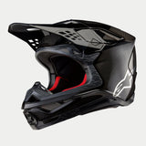 Casco Alpinestars Supertech M10 Fame ECE 22.06, casco da motocross, finitura in carbonio nero opaca e lucida con trama in fibra di carbonio a vista, logo Astar bianco sul lato e imbottitura interna rossa, design aerodinamico da fuoristrada