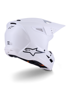 Casco Alpinestars S-M3 Solid, casco da motocross, bianco lucido, vista posteriore a tre quarti che mostra il logo Alpinestars nero, prese d'aria e design aerodinamico della calotta per gare off-road
