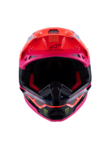Casco Alpinestars Supertech M10 Deegan Monster ECE 22.06, vista frontale del casco da motocross in arancione fluo, viola e rosa lucido, con loghi ad artiglio Monster Energy sulla mentoniera nera, design aerodinamico con prese d'aria integrate, protezione per la testa premium per competizioni off-road