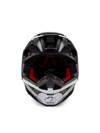 Casco Alpinestars Supertech M10 Ampress, casco da motocross, nero e bianco opaco, vista frontale con rivestimento interno rosso, calotta aerodinamica con porte di ventilazione e logo Alpinestars
