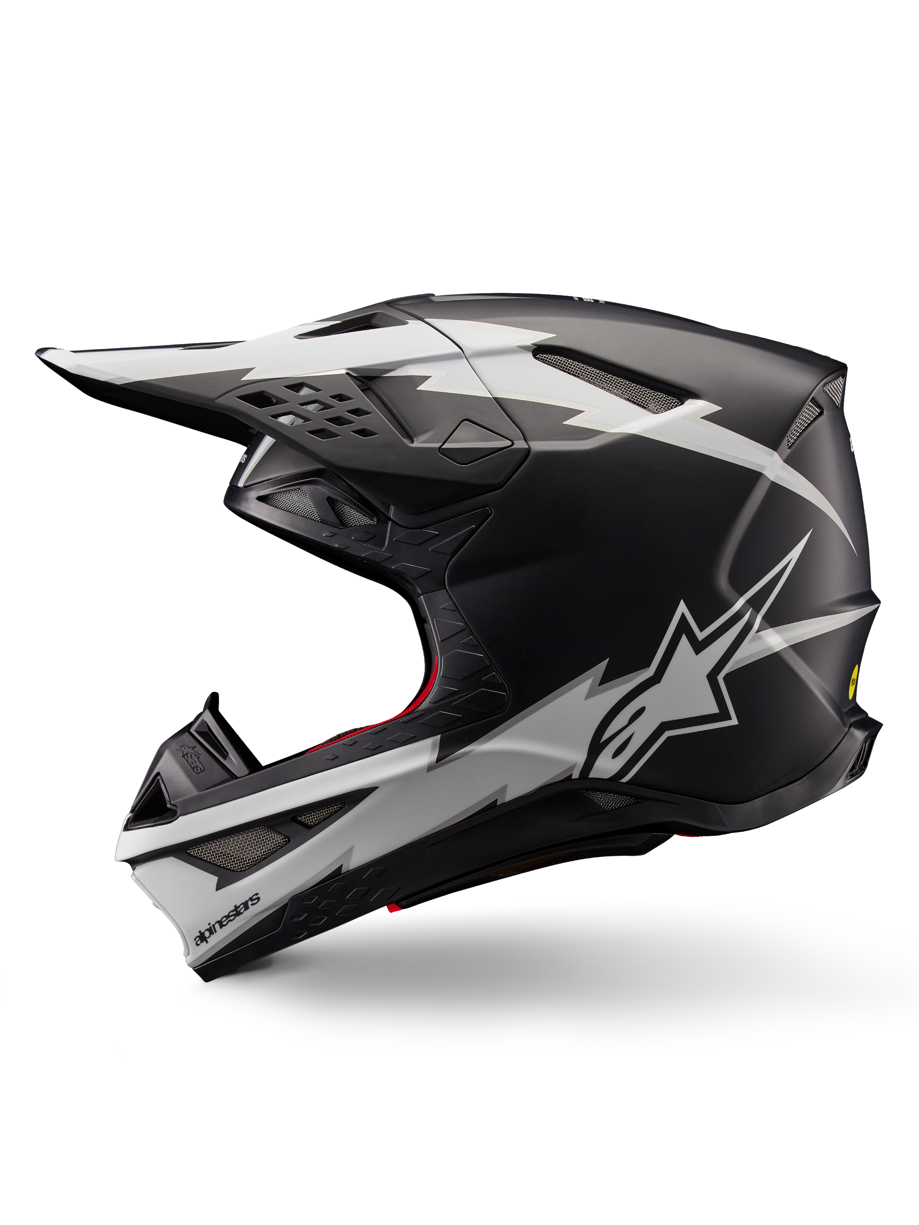 Casco Alpinestars Supertech M10 Ampress, casco da motocross, nero opaco e bianco, vista di profilo con grafiche audaci bianche in stile fulmine, calotta aerodinamica con prese d'aria visibili e visiera, protezione avanzata per il fuoristrada