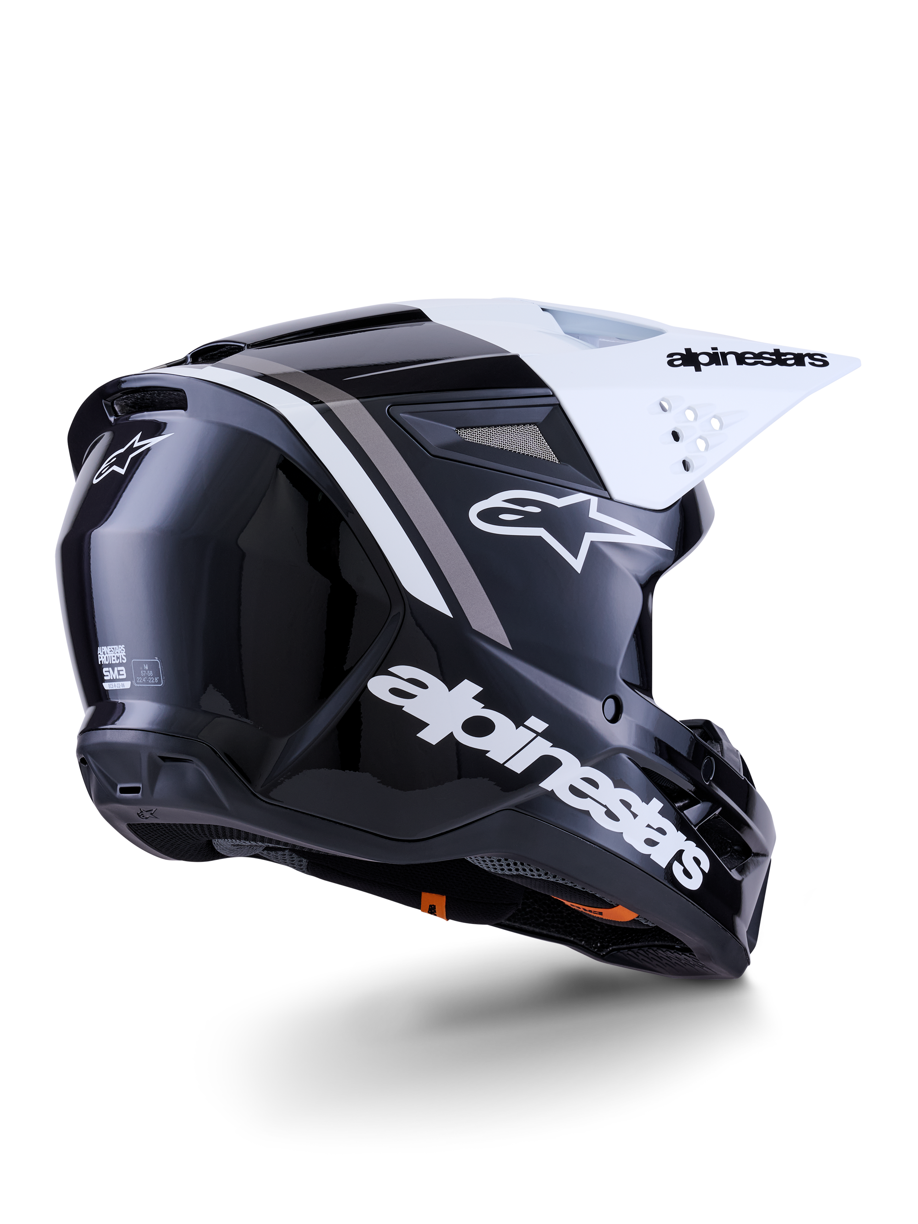 Casco Alpinestars S-M3 Radium, casco da motocross, nero, bianco e grigio lucido, vista posteriore-laterale con visiera bianca, con logo Alpinestars sul lato e sul retro, calotta aerodinamica con rete di ventilazione, progettato per motocross fuoristrada ed enduro