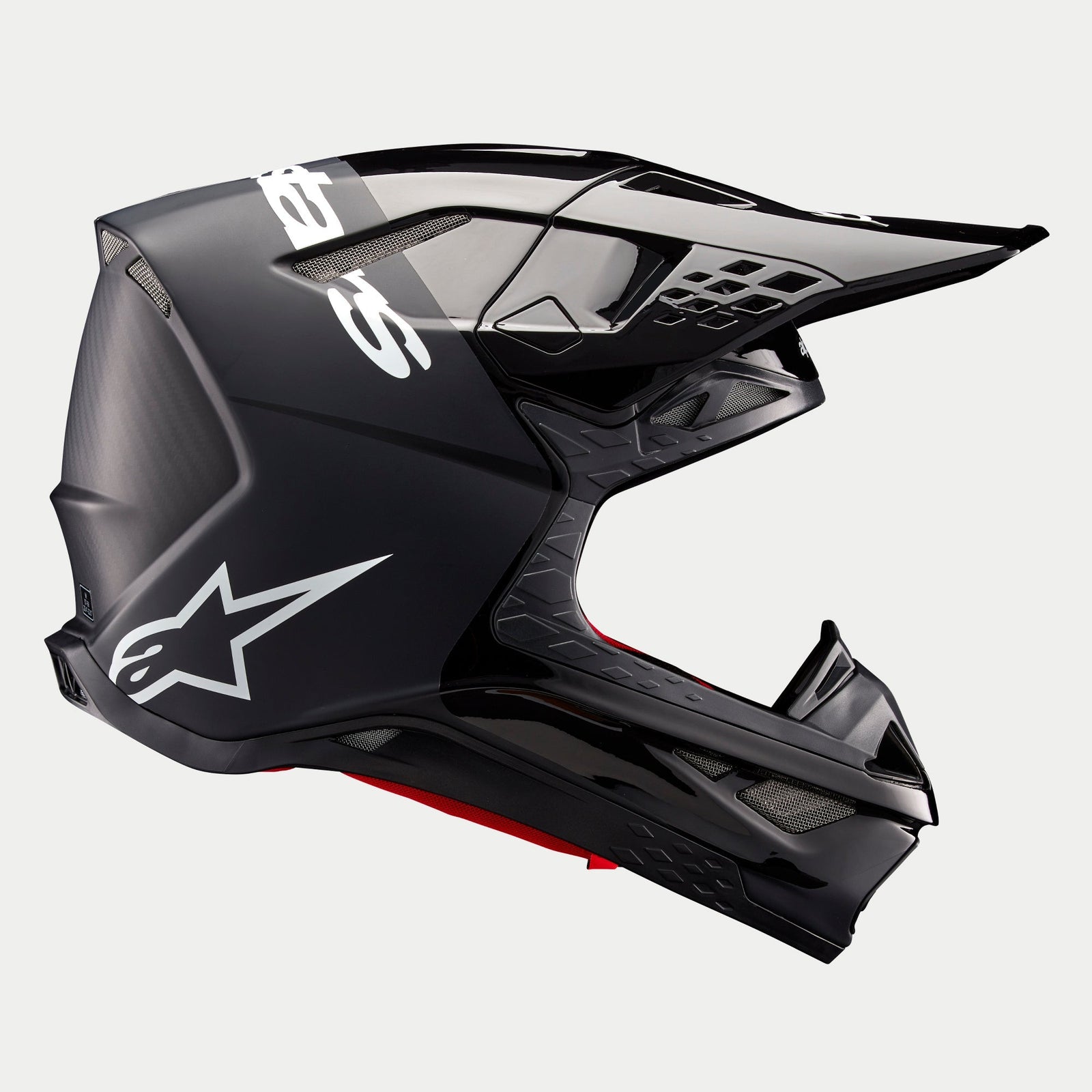 Alpinestars Supertech M10 Flood Helmet ECE, casco da motocross, nero e grigio scuro con finitura opaca e lucida, vista laterale di profilo con design aerodinamico, visiera integrata e marchio Alpinestars bianco