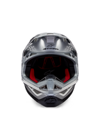 Casco Alpinestars Supertech M10 Flood ECE 22.06, casco da motocross, argento, nero e arancione fluo, vista frontale con calotta aerodinamica, ampia apertura per la maschera con imbottitura interna rossa, logo Alpinestars nero e mentoniera ventilata per gare fuoristrada
