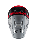 Casco Alpinestars Supertech M10 Flood ECE 22.06, casco da motocross, argento e nero con arancione fluorescente, vista dall'alto che mostra il marchio evidente sulla calotta, logo Astars nero sulla visiera, profilo aerodinamico snello con porte di ventilazione, finiture opache e lucide.
