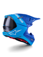 Casco Alpinestars Supertech M10 Flood, casco da motocross, azzurro e blu navy con fibra di carbonio nera a vista, profilo posteriore-laterale che mostra le porte di ventilazione e il logo bianco, interno rosso, design aerodinamico avanzato per prestazioni off-road