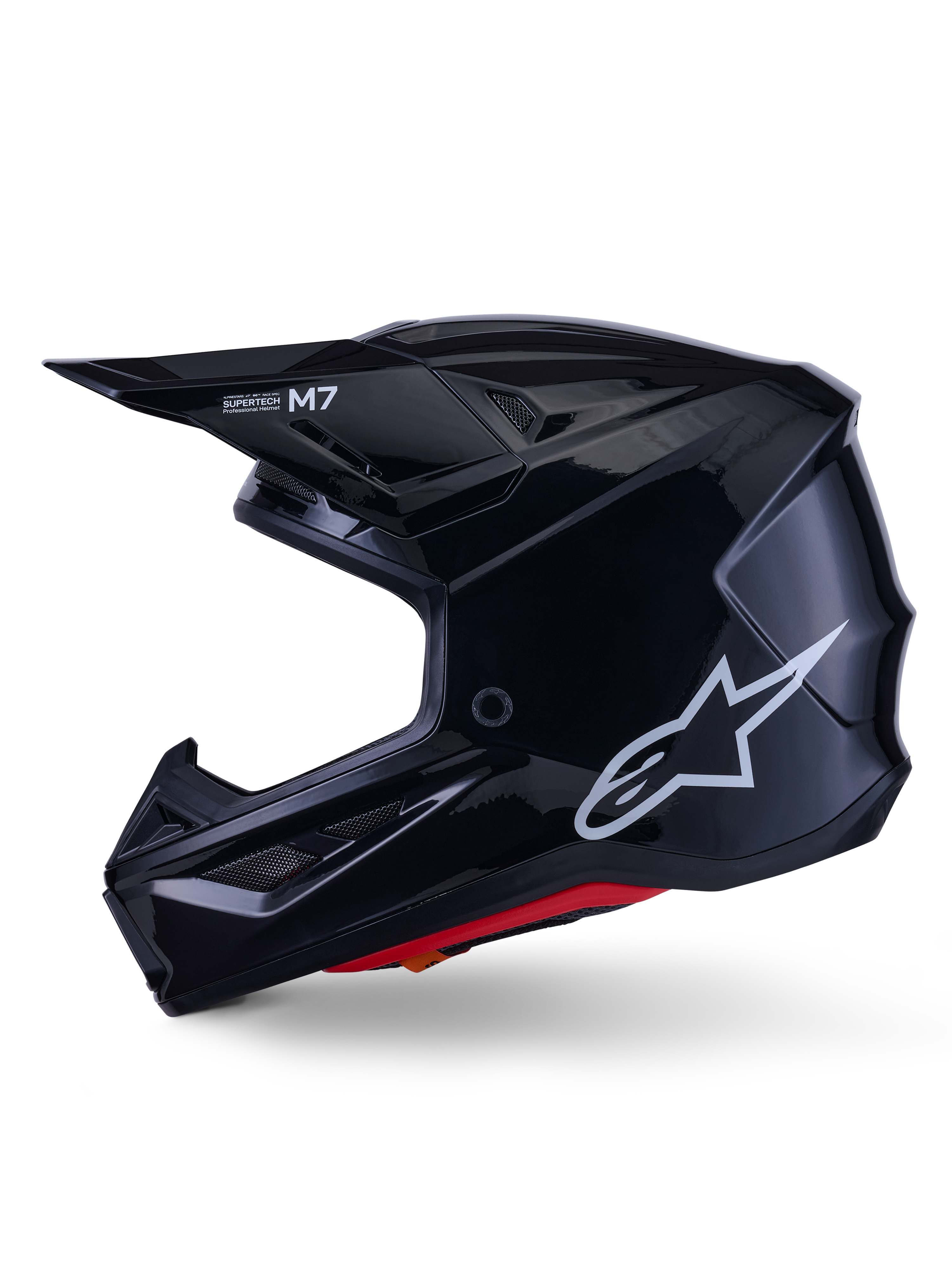 Casco Alpinestars S-M7 Solid, casco da motocross nero lucido, profilo laterale con logo Alpinestars bianco, calotta aerodinamica con rete di ventilazione e imbottitura interna rossa, protezione avanzata per il fuoristrada