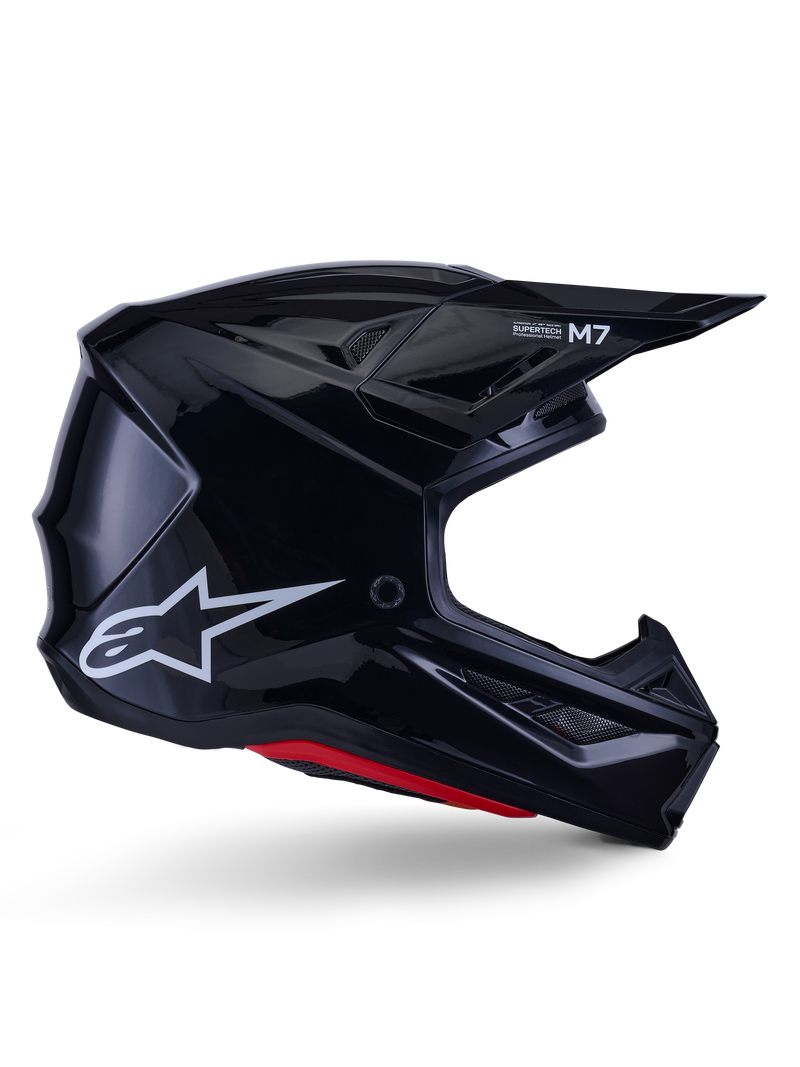 Alpinestars S-M7 Solid Helmet, casco da motocross, nero lucido con logo a stella bianco e dettagli rossi, profilo laterale con design aerodinamico, prese d'aria in rete e branding Supertech M7 sulla visiera