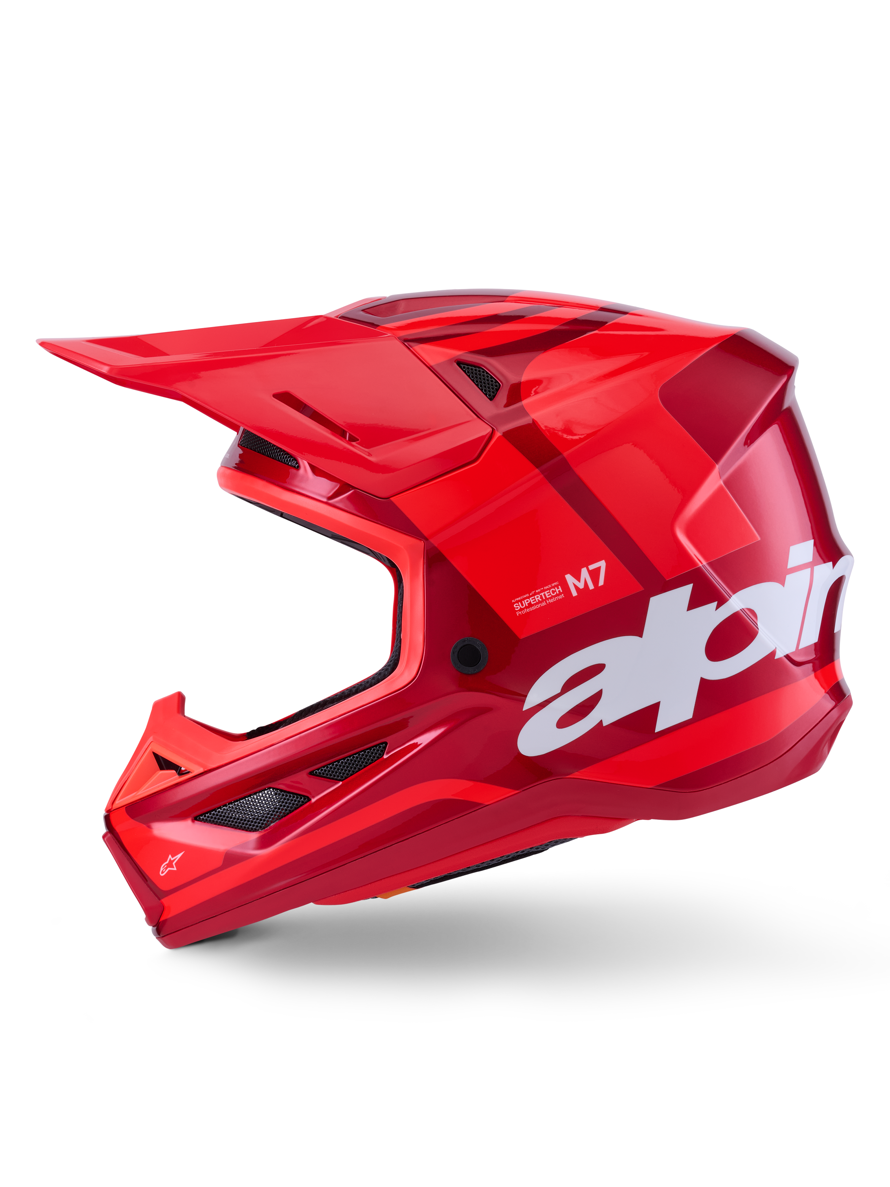 Casco Alpinestars S-M7 Core, rosso lucido con accenti geometrici, casco da motocross, vista laterale, calotta aerodinamica con prese d'aria e loghi bianchi, equipaggiamento professionale per fuoristrada