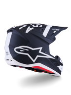 Alpinestars S-M7 Dasher Helmet, casco da motocross, nero opaco e bianco, vista di tre quarti posteriore con grande logo A-star bianco sul lato, marchio bianco sulla parte superiore, design della calotta aerodinamico con prese d'aria visibili e imbottitura rossa.