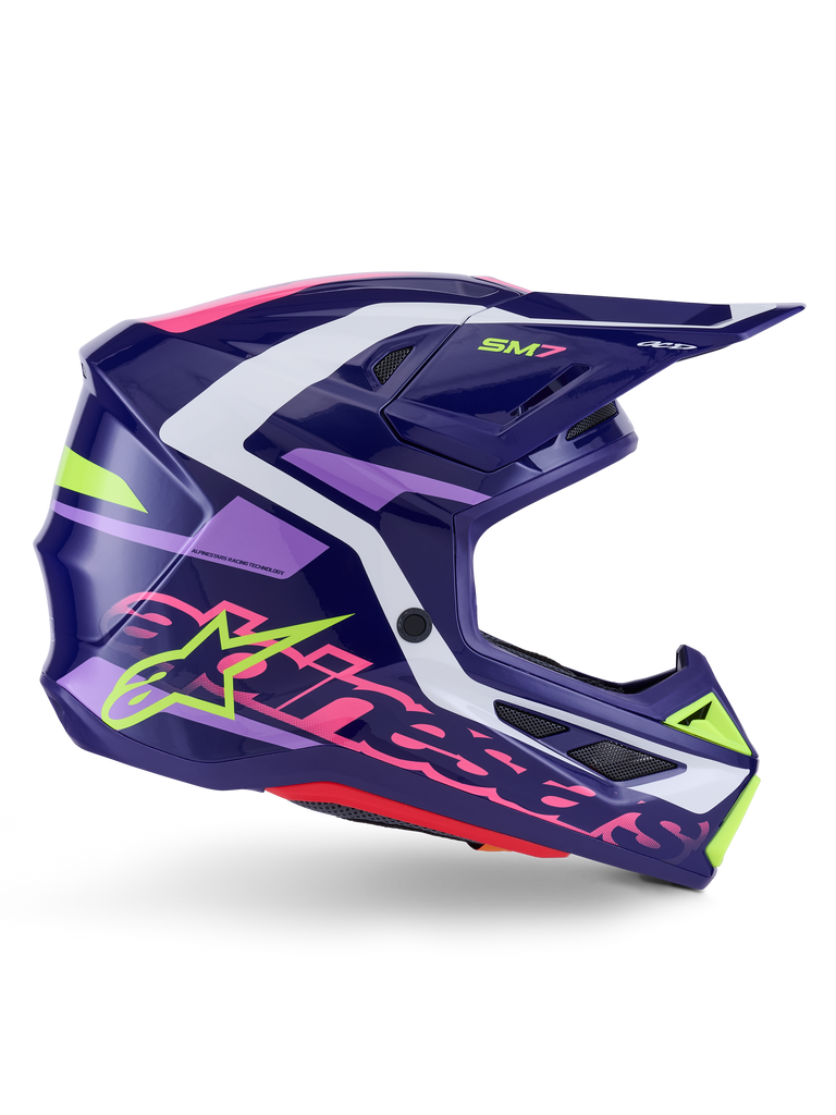 Casco Alpinestars S-M7 Deed, casco da motocross, viola e rosa lucido, vista laterale, con accenti grafici bianchi e verde lime, branding SM7 e logo Alpinestars, design della calotta aerodinamica in materiale composito per corse fuoristrada