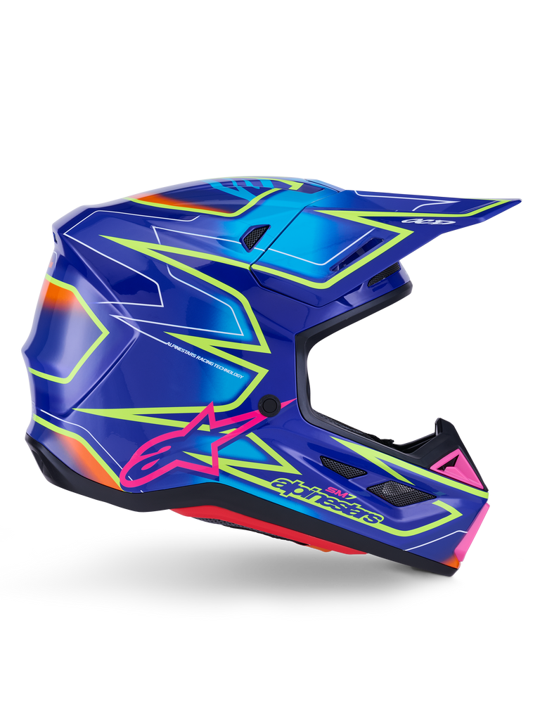Casco Alpinestars S-M7 Cast, casco da motocross, blu, rosa e giallo fluo lucido, vista di profilo laterale con motivi geometrici audaci, logo Alpinestars rosa e calotta aerodinamica ventilata