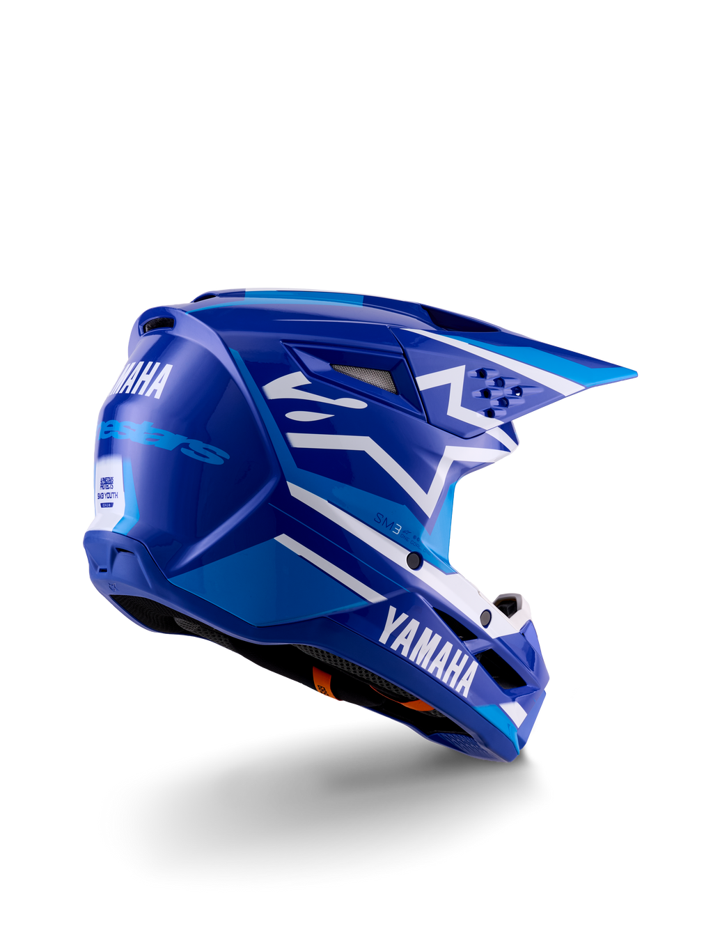 Casco da motocross Alpinestars Yamaha S-M3 per ragazzi, blu e bianco lucido, con marchio Yamaha evidente sul lato e sul retro, design aerodinamico della calotta con ventilazione posteriore, protezione per la testa off-road specifica per ragazzi in una vista posteriore a tre quarti.