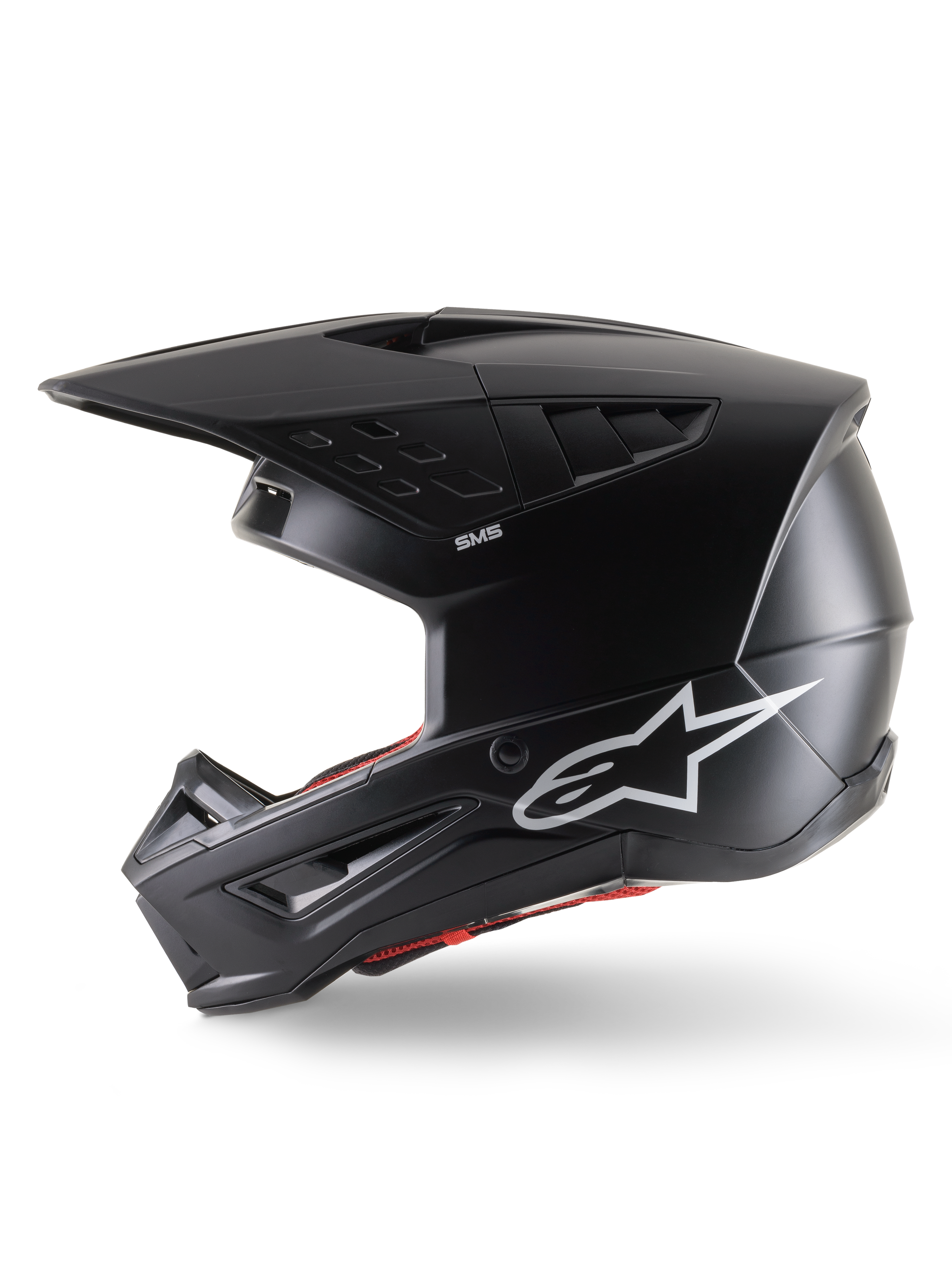 Casco Alpinestars S-M5 Solid ECE 22.06, casco da motocross, nero opaco, vista laterale di profilo con finitura opaca, logo Alpinestars bianco sul lato, imbottitura interna rossa e calotta aerodinamica con porte di ventilazione integrate