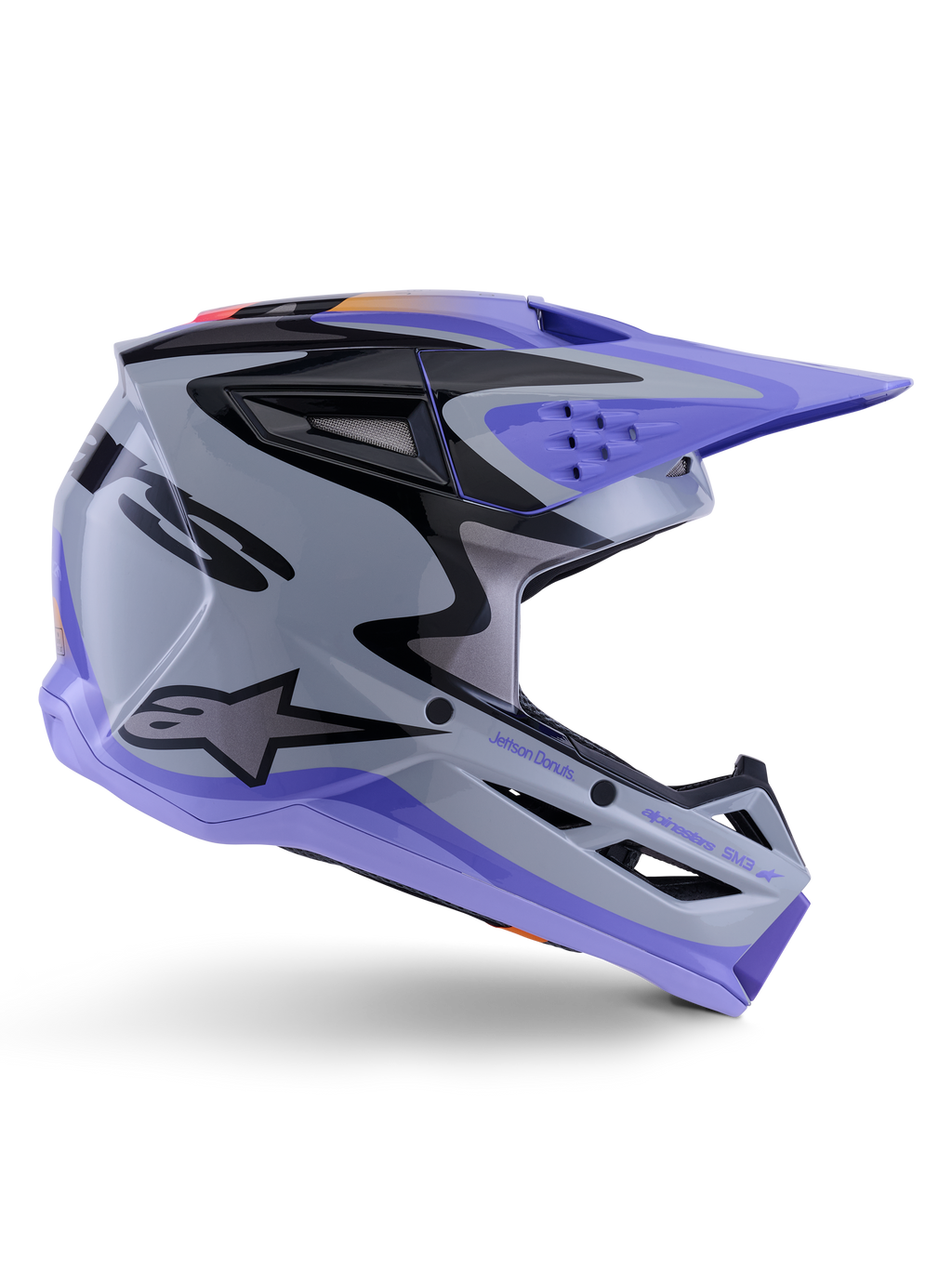 Casco Alpinestars S-M3 Jettson Youth, casco da motocross, grigio, viola e nero lucido, profilo laterale con grafiche angolari e marchio 'Jettson Donuts', design aerodinamico della calotta con prese d'aria e logo Alpinestars, attrezzatura protettiva off-road per ragazzi ad alte prestazioni