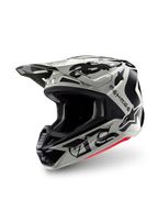 Casco Alpinestars S-M7 Wolf Dust Edizione Limitata, casco da motocross, Dune Black Glossy, calotta grigio chiaro con scritte gotiche 'ASTARS' nere e logo a stella, accento rosso sul bordo inferiore, dotato di visiera ad alte prestazioni e molteplici prese d'aria, vista frontale a tre quarti