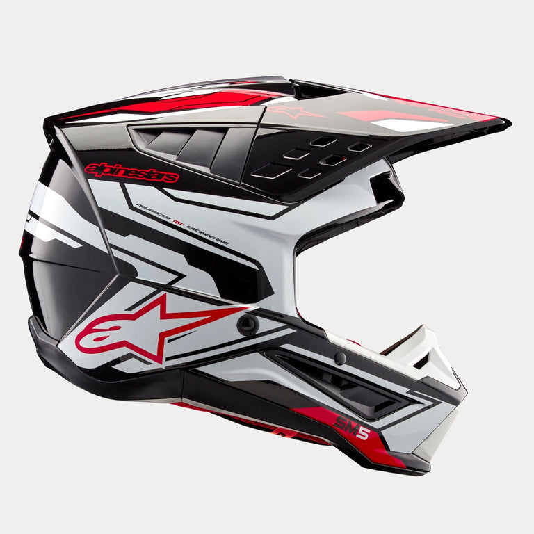 Alpinestars S-M5 Action 2 Helmet ECE, casco da motocross, nero bianco e rosso brillante lucido, vista laterale che mostra grafiche audaci e il logo a stella rosso, calotta aerodinamica con prese d'aria multiple, visiera regolabile, equipaggiamento ad alte prestazioni per gare fuoristrada