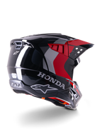 Casco Alpinestars Honda S-M5 ECE, casco da motocross, nero rosso lucido, vista posteriore di tre quarti con marchio Honda e loghi Alpinestars, finitura lucida con accenti grafici rossi e grigi, progettato per la protezione fuoristrada