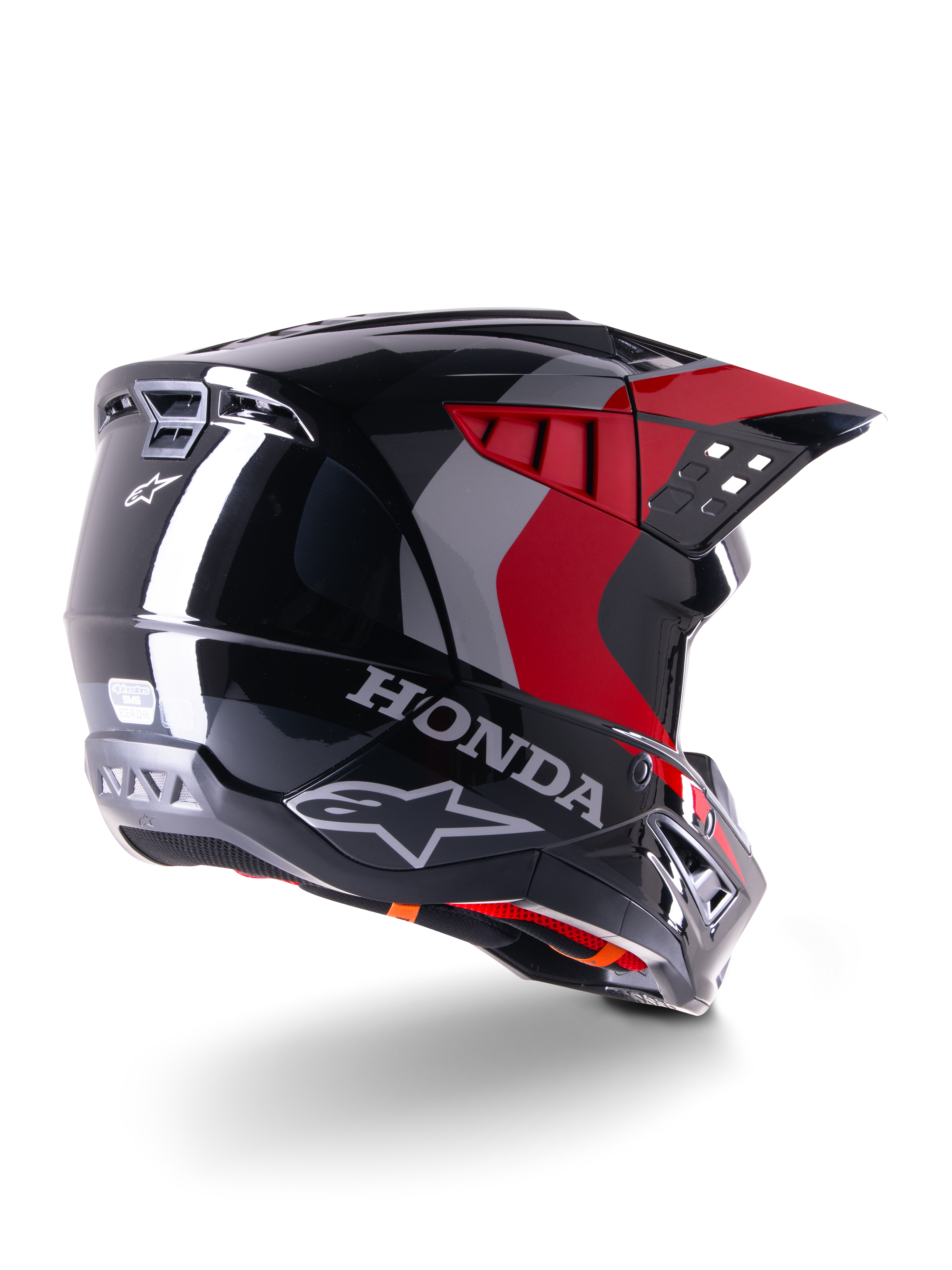 Casco Alpinestars Honda S-M5 ECE, casco da motocross, nero rosso lucido, vista posteriore di tre quarti con marchio Honda e loghi Alpinestars, finitura lucida con accenti grafici rossi e grigi, progettato per la protezione fuoristrada