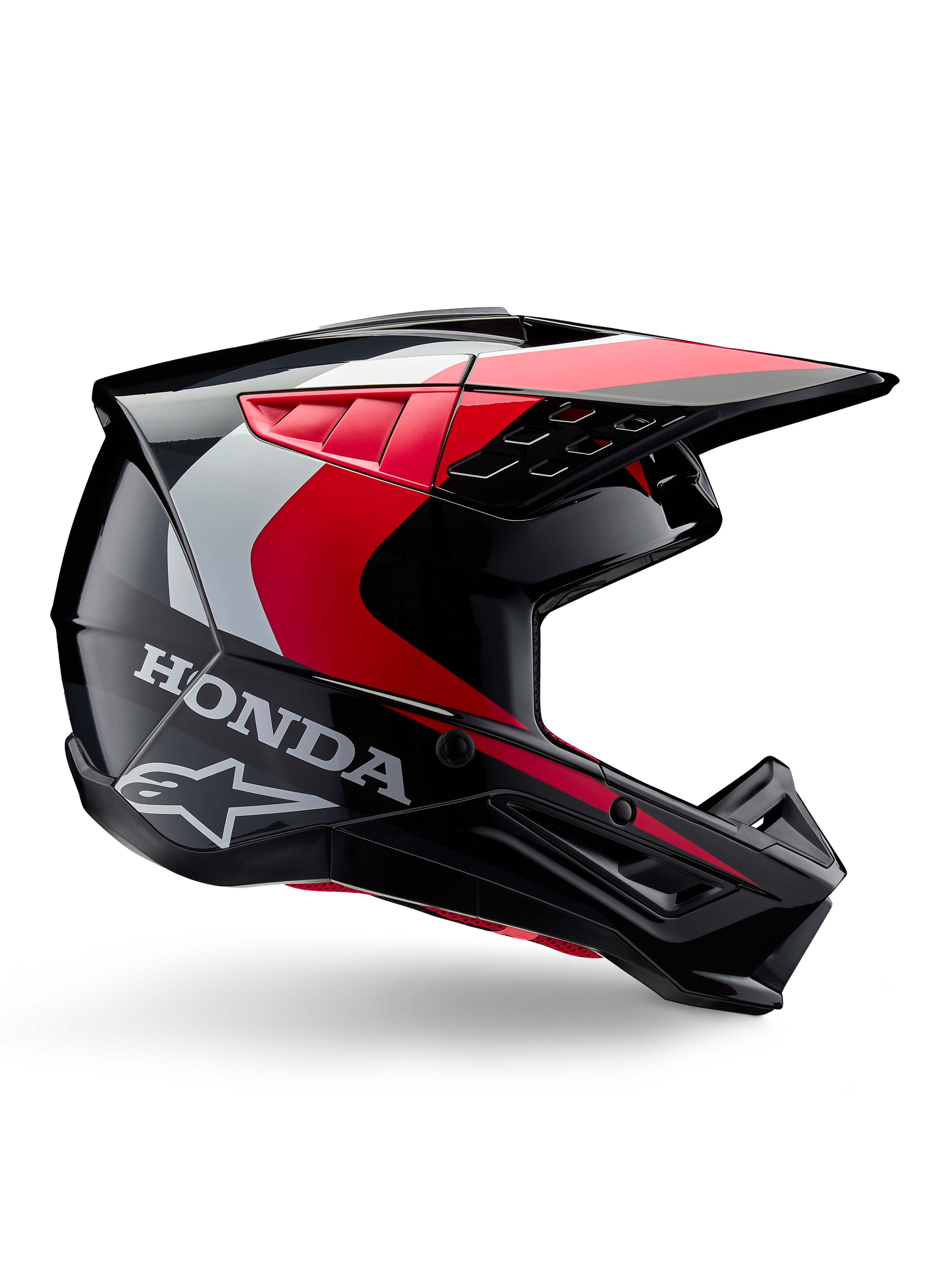 Casco Honda S-M5, casco da motocross, nero e rosso lucido con dettagli bianchi e argento, vista laterale con loghi Honda e Alpinestars, design aerodinamico con visiera e molteplici prese d'aria, equipaggiamento protettivo professionale per fuoristrada