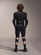Alpinestars A-Impact Plasma Protection Jacket - Maniche Lunghe, vista posteriore, nera con loghi Alpinestars bianchi, indossata con pantaloncini protettivi e ginocchiere per una protezione completa da mountain bike
