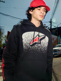 Alpinestars Obsessed Hoodie, felpa in pile nera, grafica sul petto con gradazione MX bianca e logo a stella rossa, loghi rossi sulle maniche, streetwear casual di ispirazione motorsport in un contesto urbano