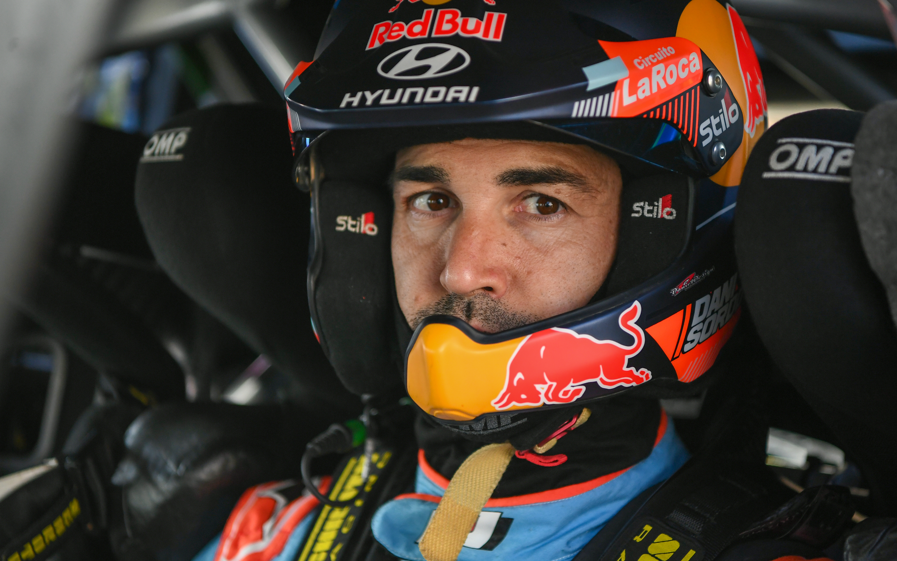 Close up shot of Dani Sordo in his Rally car, clothed with an Alpinestars suit