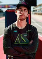Alpinestars Ayess Csf Tee, maglietta a maniche lunghe, nero, con grafiche AS con sfumatura verde e gialla sul petto e sulle maniche, streetwear casual ispirato al motorsport indossato in un circuito