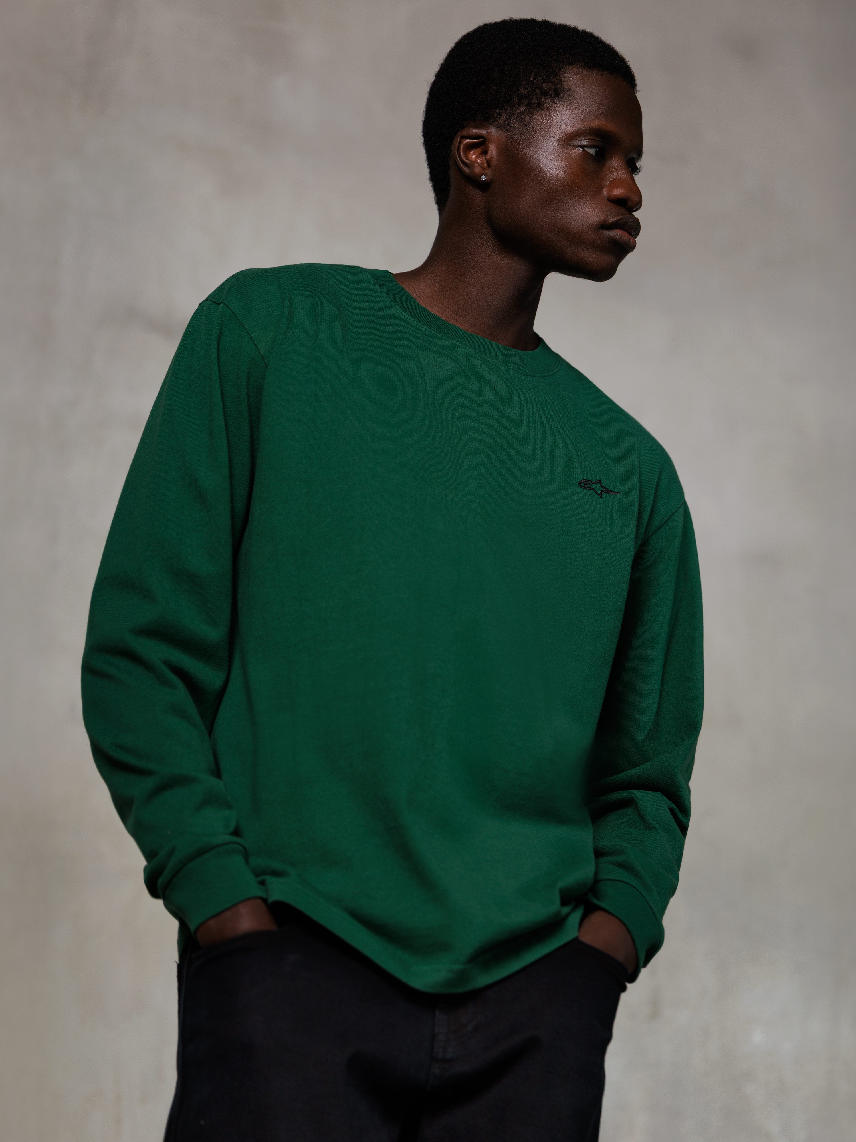 Alpinestars Essentials Ageless LS Tee, maglia a maniche lunghe, verde pino, piccolo logo nero sul petto, girocollo, vestibilità rilassata, streetwear casual in cotone organico premium