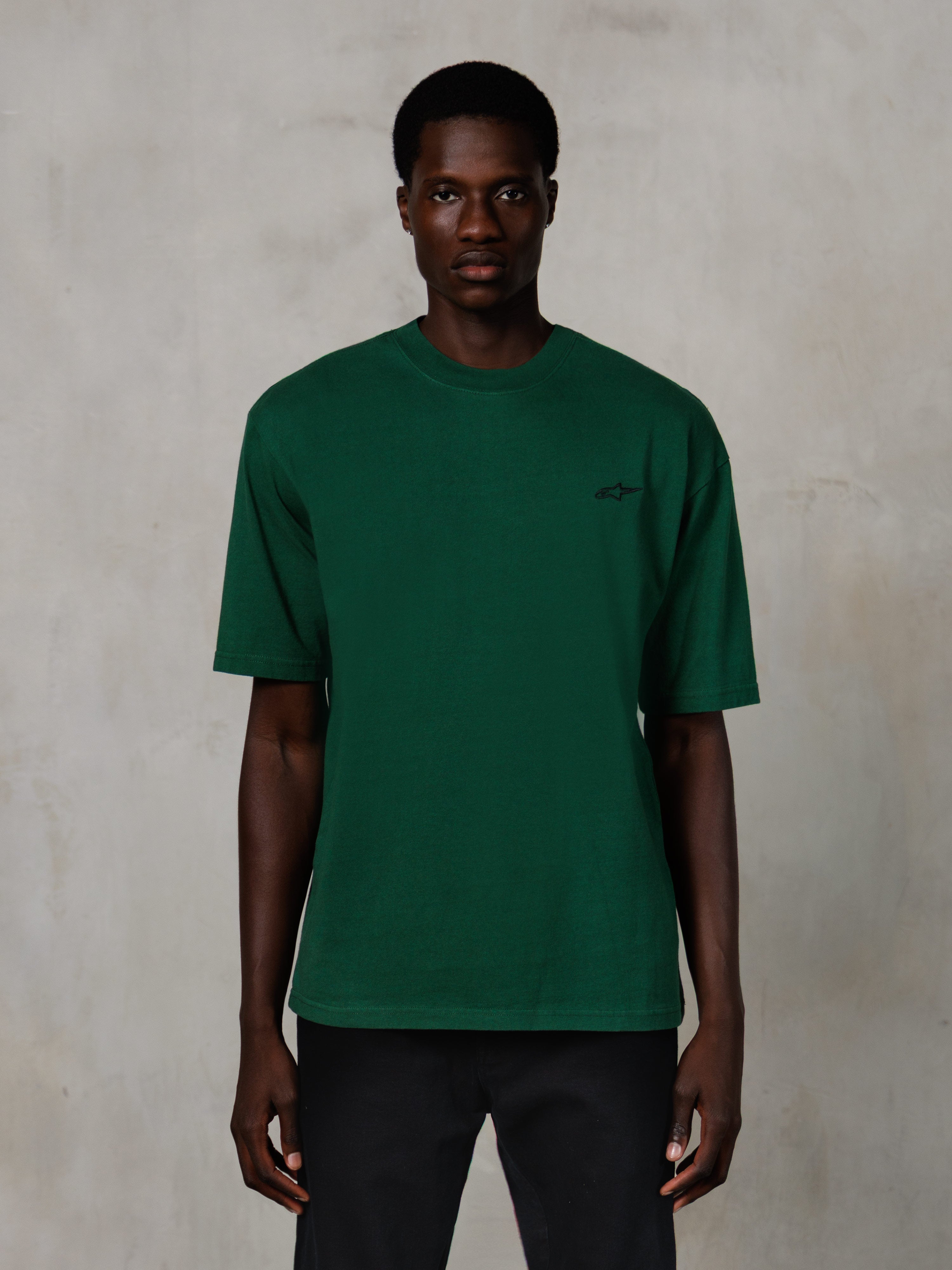 Alpinestars Essentials Ageless SS Tee, maglietta a maniche corte, verde pino, con un piccolo logo nero sul petto, vestibilità rilassata, abbigliamento streetwear casual