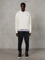 Felpa con cappuccio e zip Alpinestars Essentials Ageless, streetwear casual, bianco sporco con discreto logo nero sul petto, chiusura frontale con zip, design con cappuccio, vestibilità rilassata, abbinata a pantaloni sportivi neri e sneakers