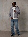 Alpinestars Essentials Ageless Zip Hoodie, Silver, streetwear casual, felpa in pile con cappuccio e zip intera con un piccolo logo nero sul petto, indossata da un modello con t-shirt bianca e jeans blu, vestibilità lifestyle rilassata