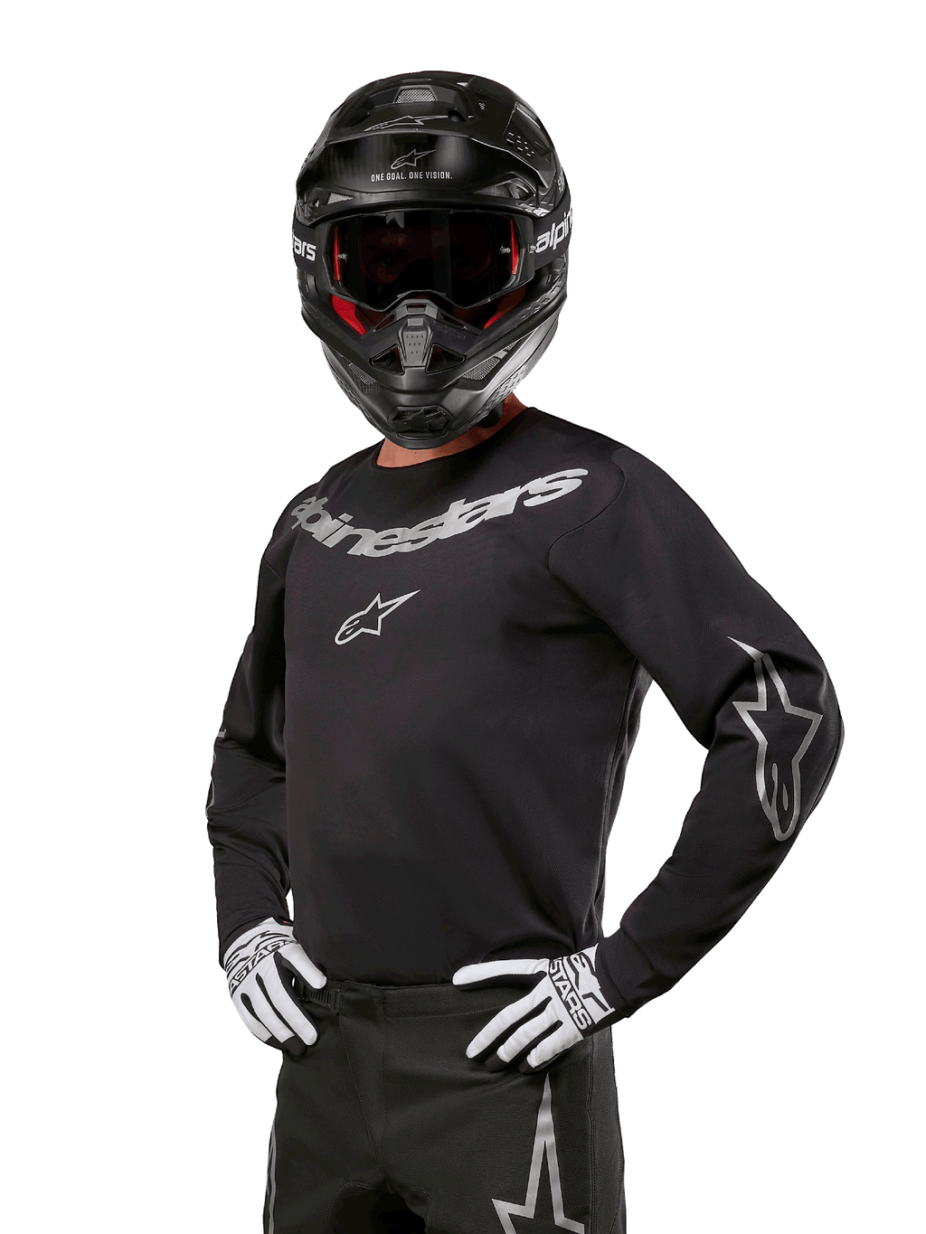 Alpinestars 2024 Fluid Graphite Jersey, maglia da motocross nera e argento, vestibilità performance a maniche lunghe, indossata con casco nero e guanti bianchi, con loghi Alpinestars argento, abbigliamento per corse fuoristrada