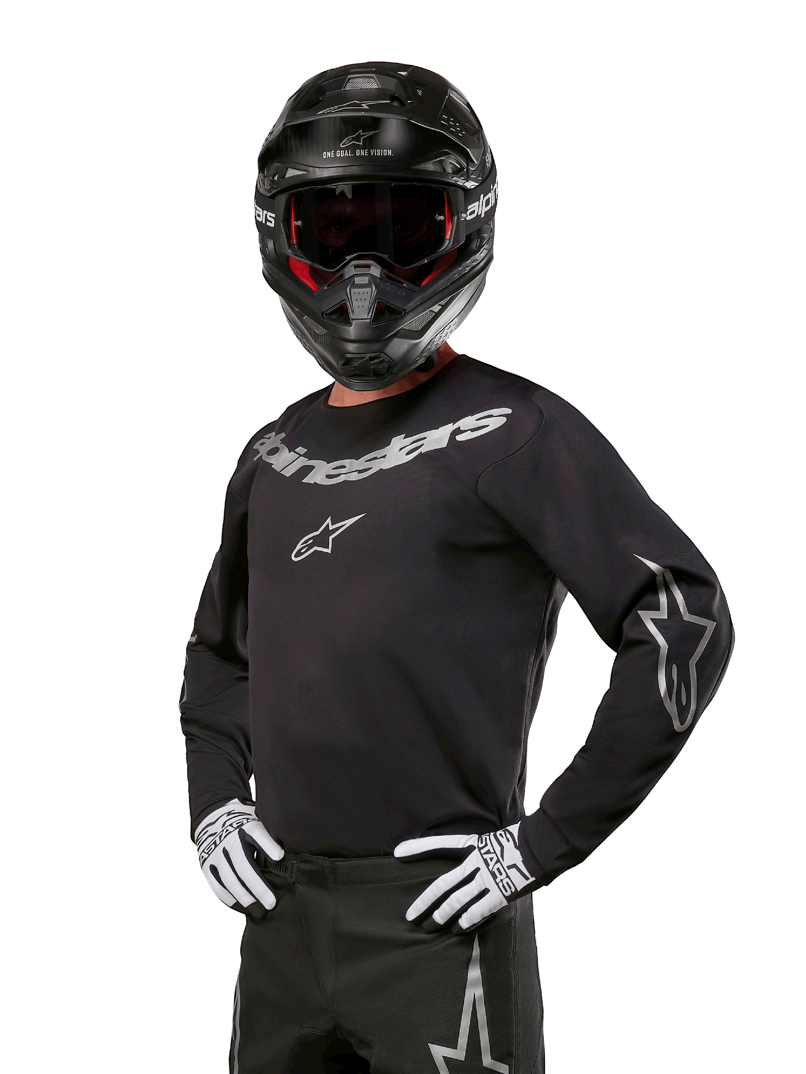 Alpinestars 2024 Fluid Graphite Jersey, maglia da motocross nera e argento, vestibilità performance a maniche lunghe, indossata con casco nero e guanti bianchi, con loghi Alpinestars argento, abbigliamento per corse fuoristrada
